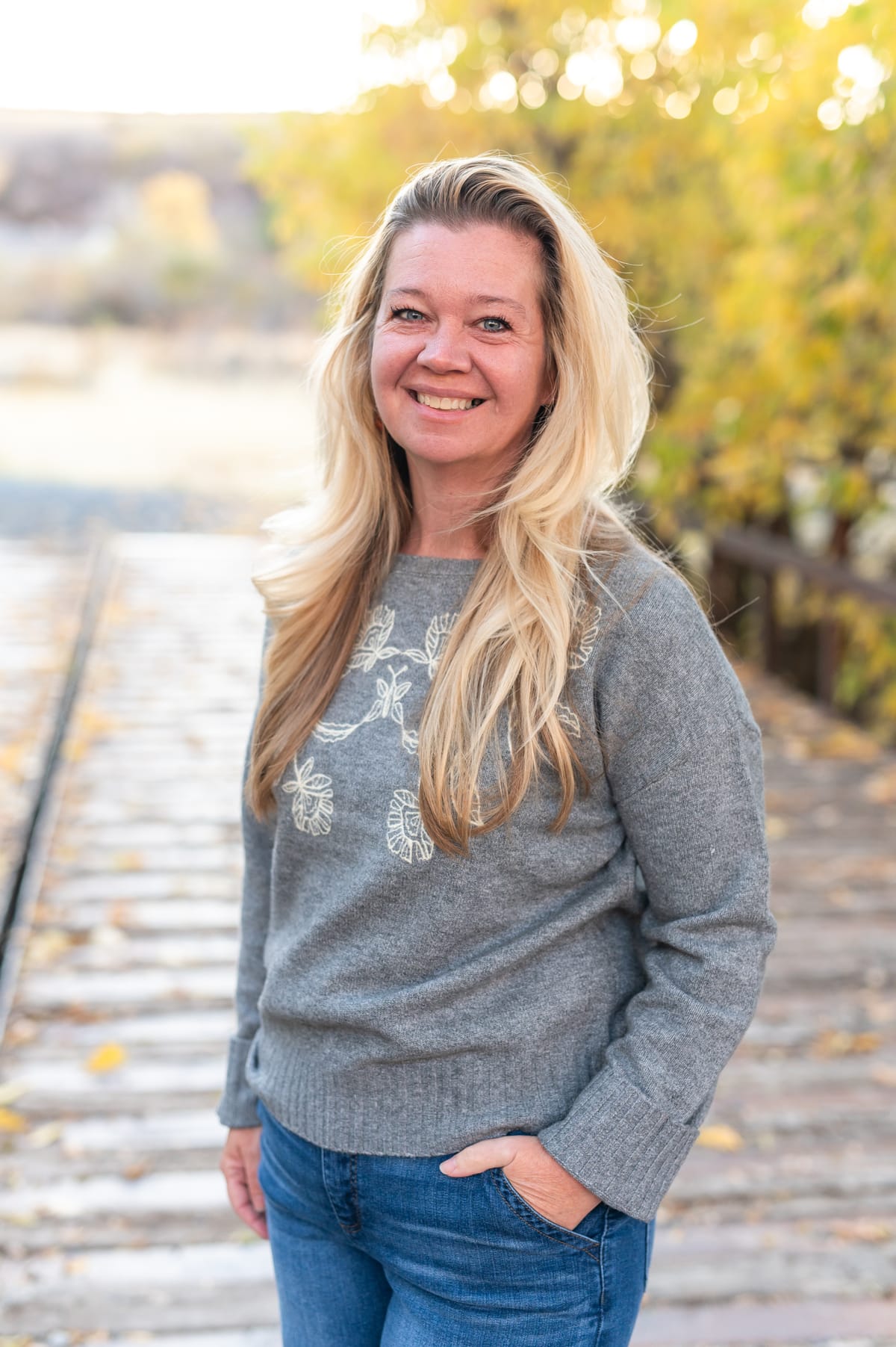 BenNi Gage on a wooden bridge beside the river in autumn