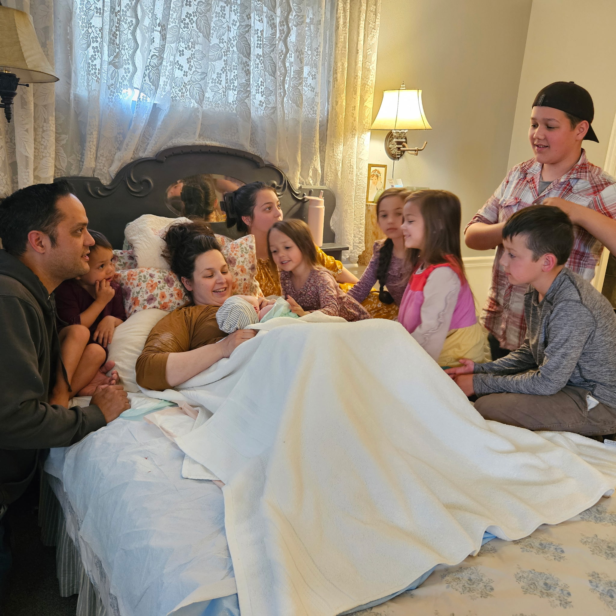 Family and siblings gathered around a newborn