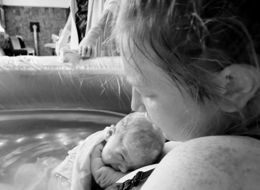 Mother kissing her newborn after a water birth